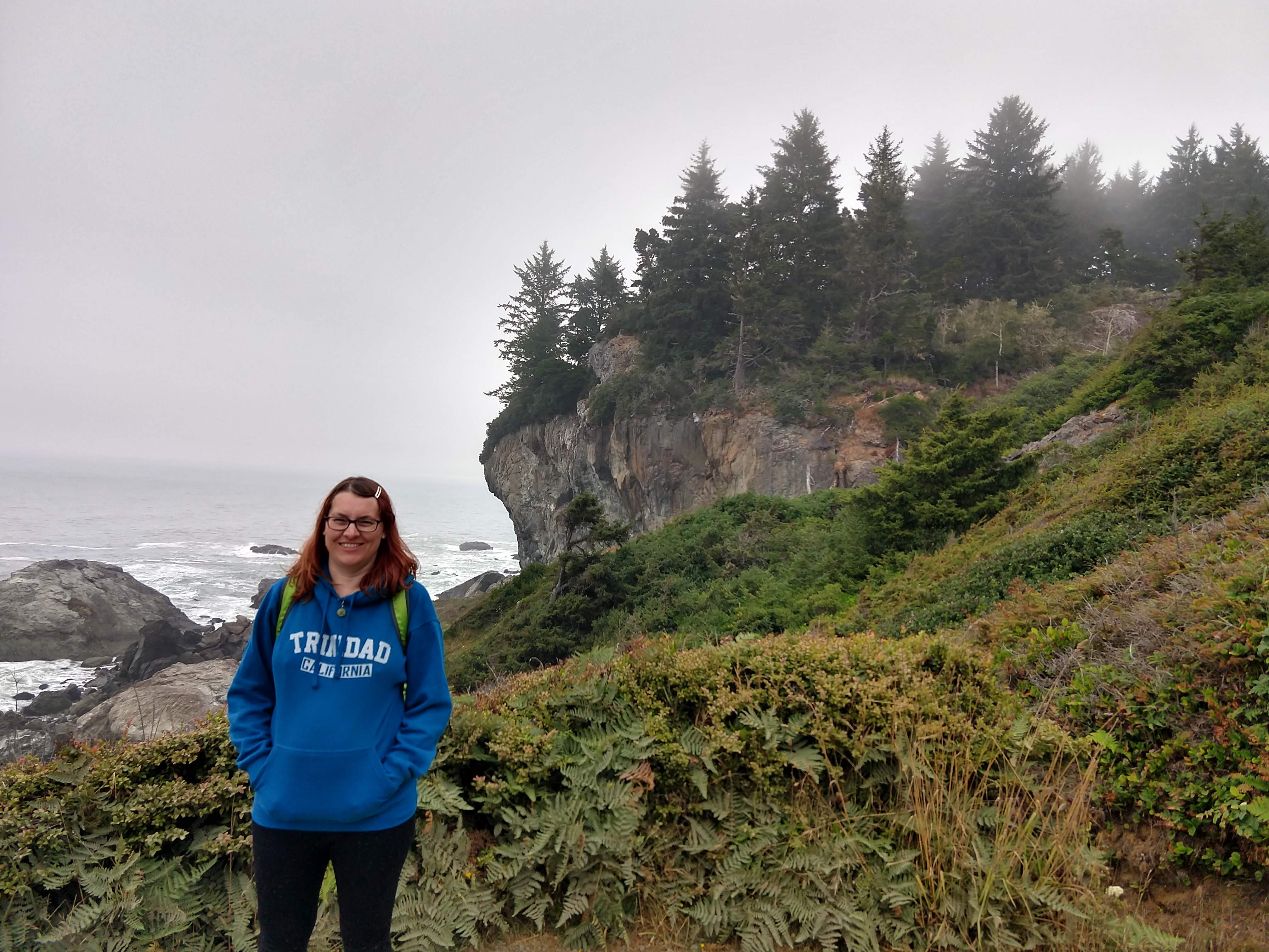 A picture of me during pregnancy, standing next to an ocean cliff